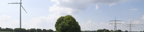 Windnergieanlage und Stromtrassen auf einem Feld