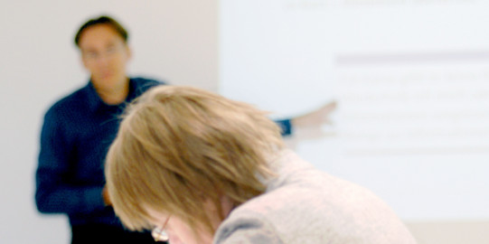 Lehrsituation mit Beamer Lehrsituation mit Beamer, Studentin schreibt mit.